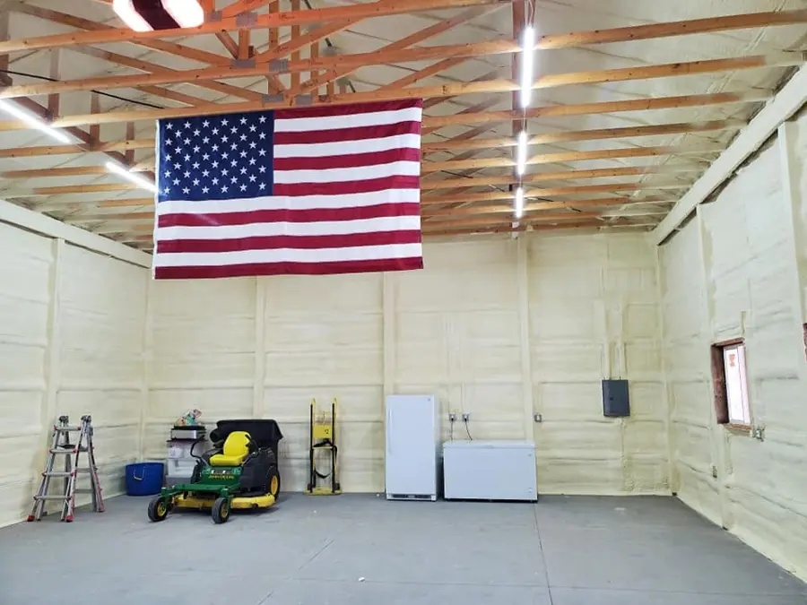 Shop interior with yellow closed-cell foam walls, American flag, John Deere mower, refrigerator and freezer